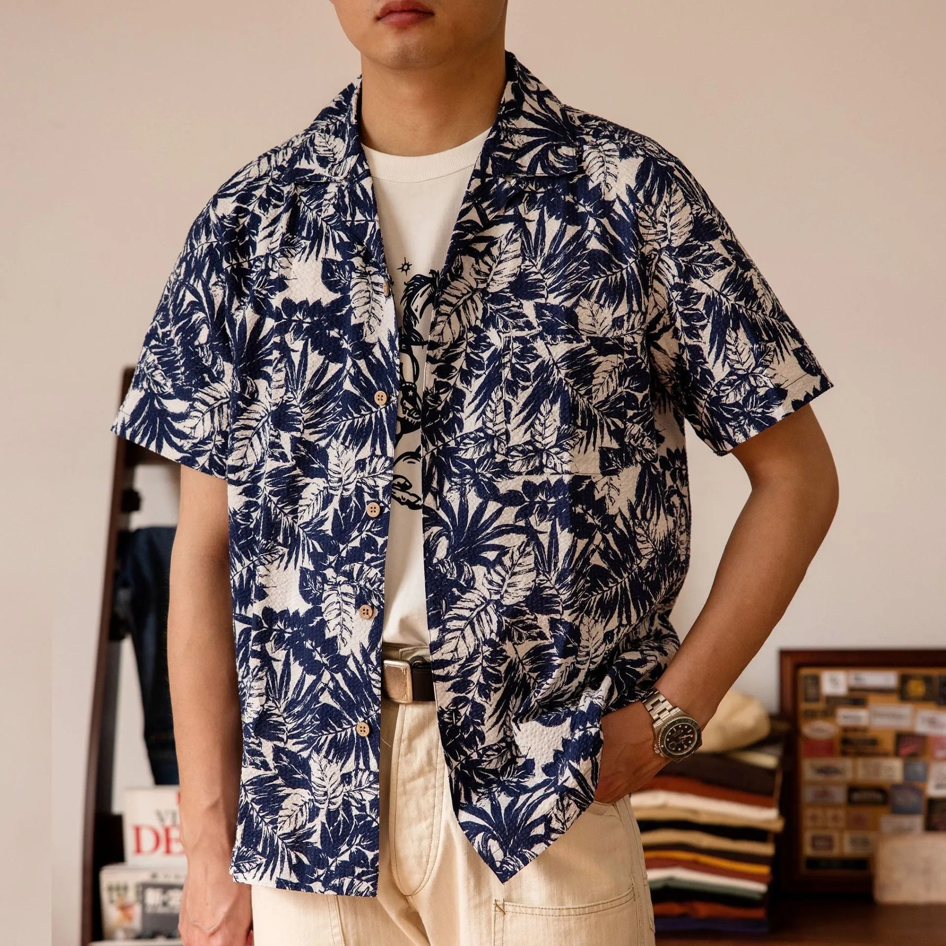 Man wearing a vintage floral print seersucker shirt with a Cuban collar in a green colour, showing loose fit.