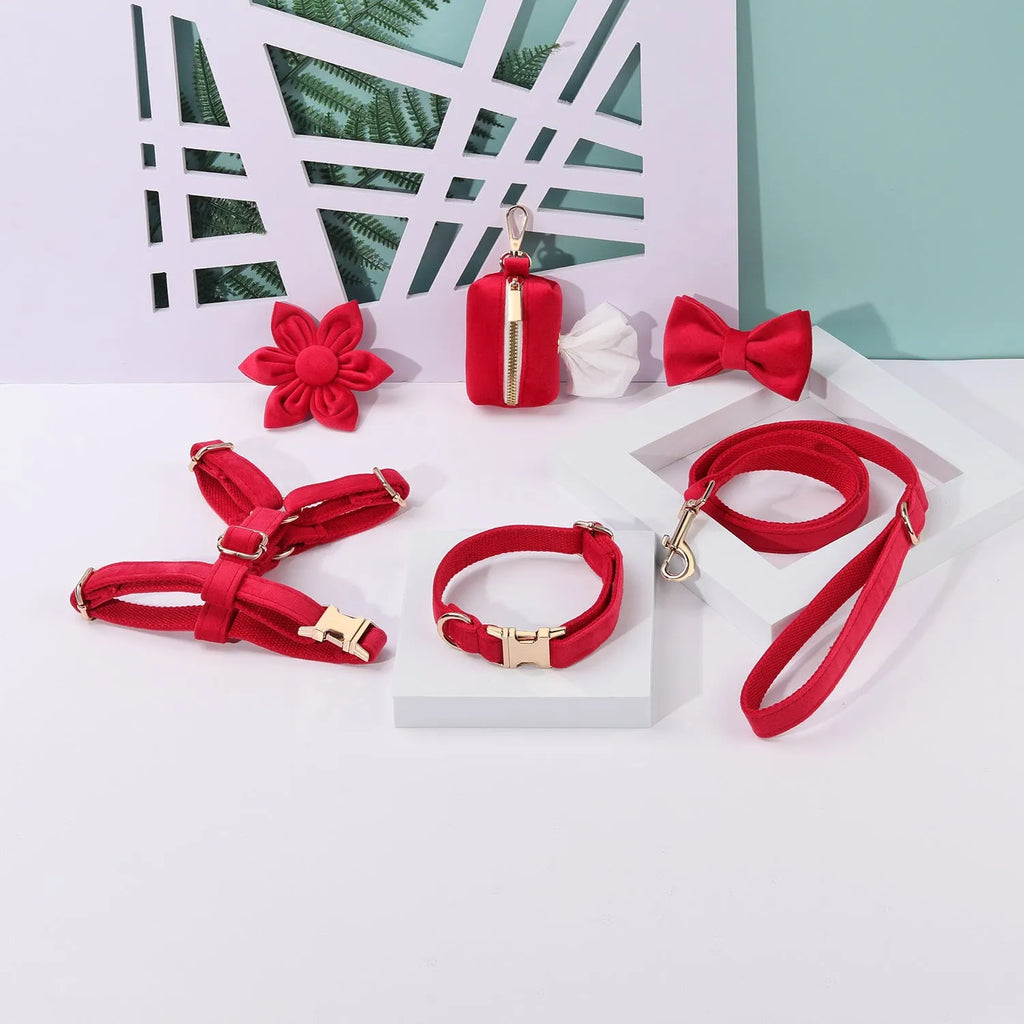 Classic velvet dog harness and lead set in red fleece with attached bow tie and waste bag holder.
