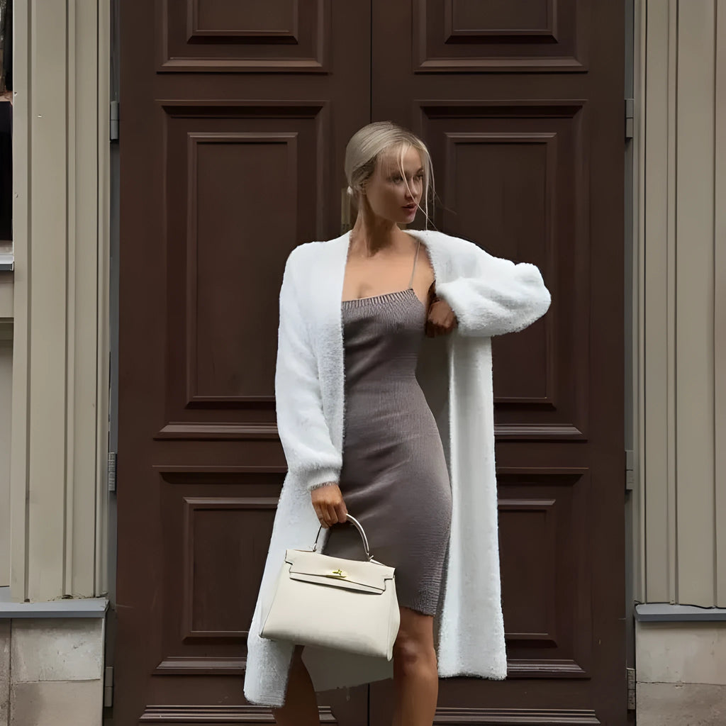 White long knitted cardigan jacket with regular sleeves on a hanger.