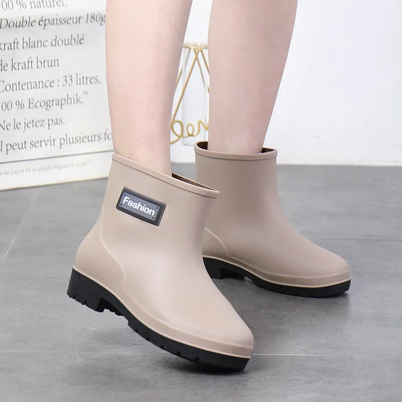 Women's mid-calf PVC rain boot in black with a low heel on a white background.