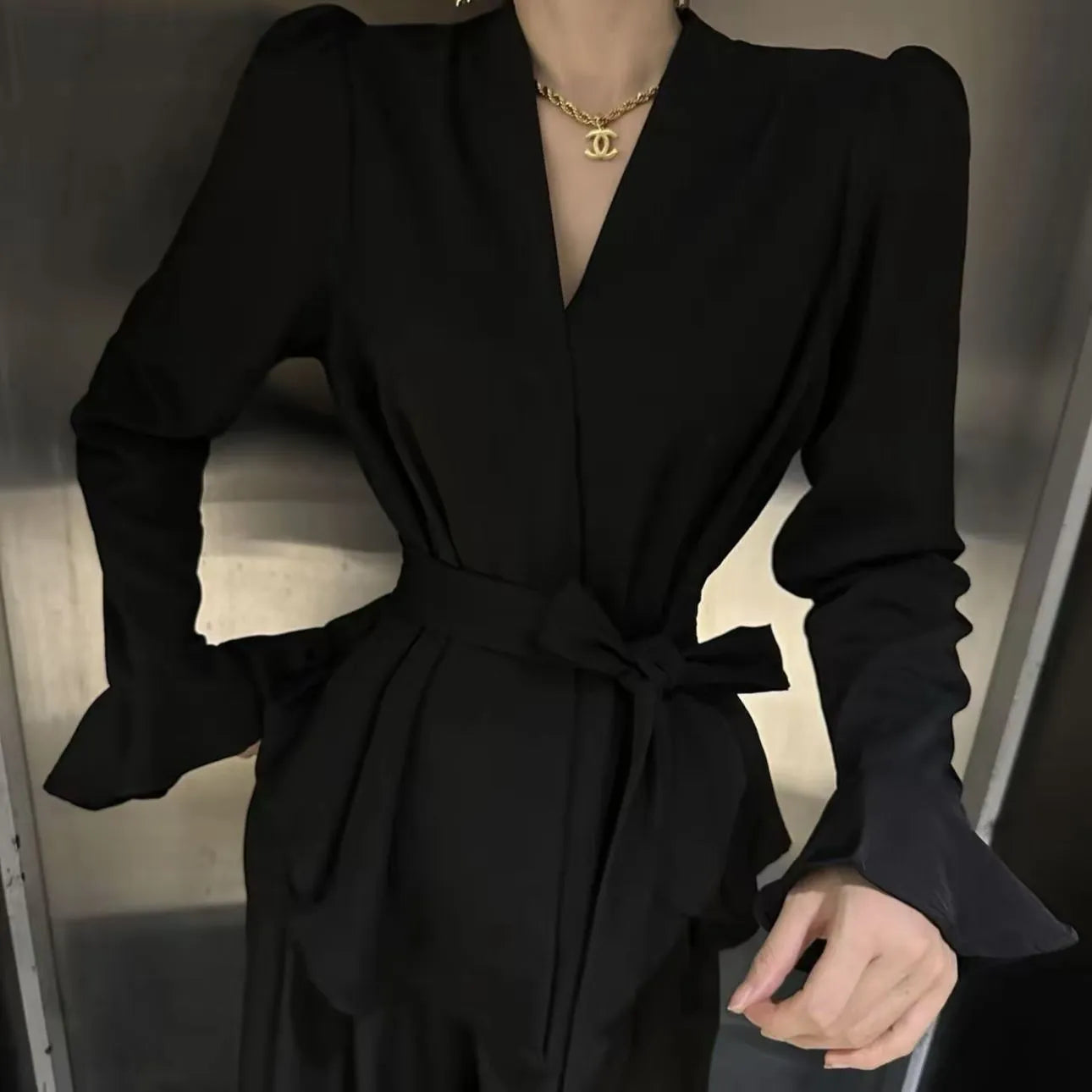 Women's black French-style tied shirt with an irregular collar and long bell sleeves.