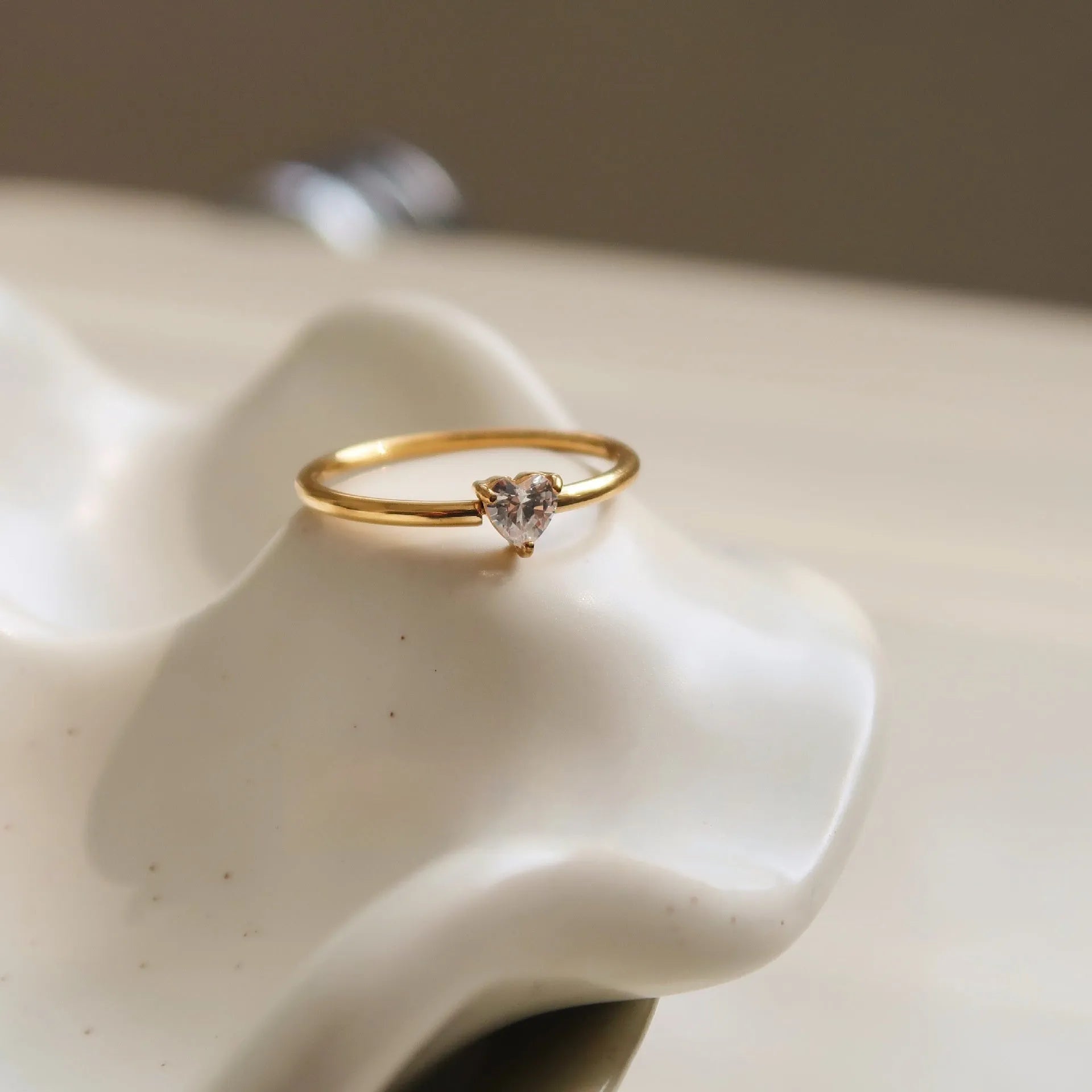 Golden stainless steel ring showing heart and oval love symbol designs with size options from 5 to 8