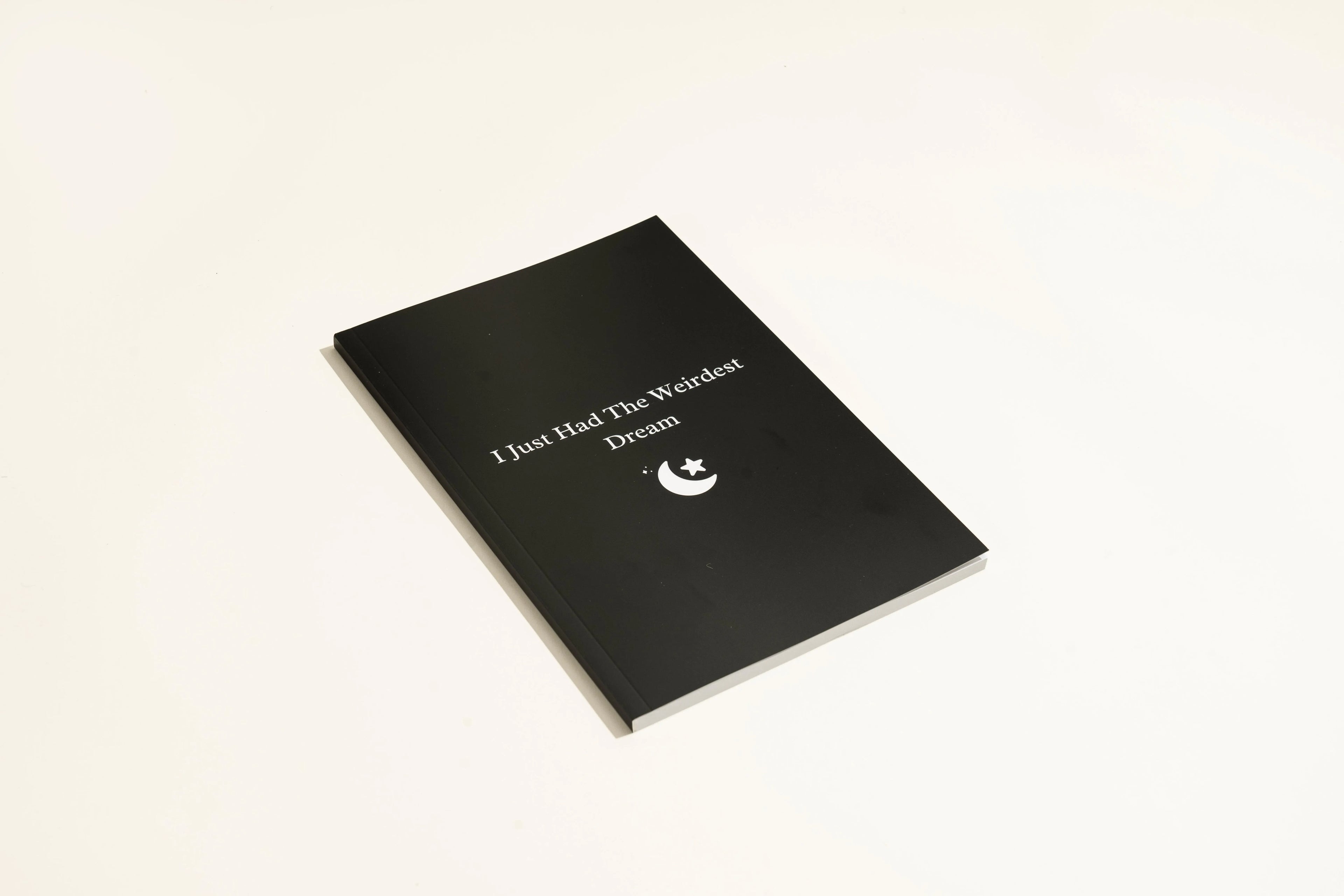Black softcover Dream Journal notebook open on a table