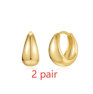 Golden brass earclip earrings with geometric round drop design on white background