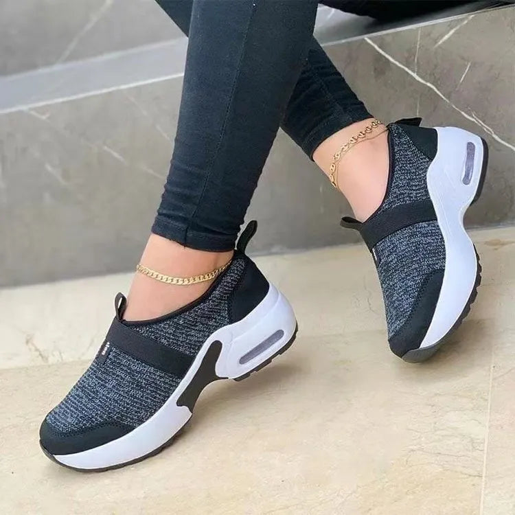 Women's flat sneakers in light grey with mesh upper, round toe, and rubber sole.