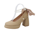 Women's beige Mary Jane shoes with a chunky heel and an ankle-strap buckle on a round toe.