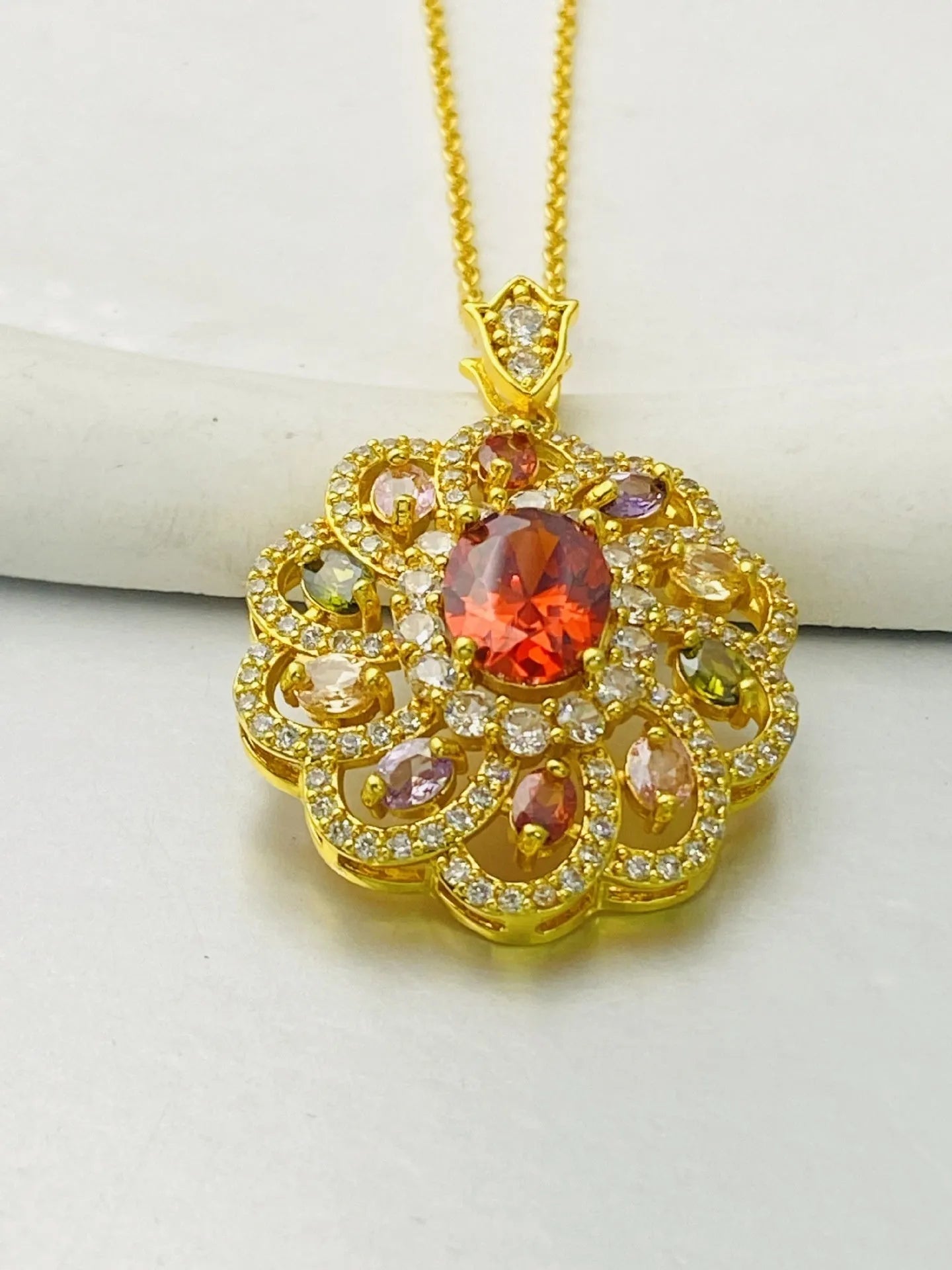 Close-up of a women's flower-shaped zircon pendant necklace in a gold electroplated finish on a model.