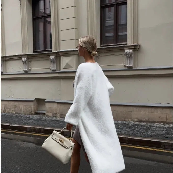 White long knitted cardigan jacket with regular sleeves on a hanger.