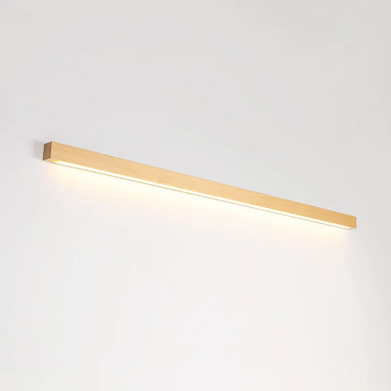 Walnut colour minimalist wooden and acrylic strip wall lamp in three length options on a white wall.