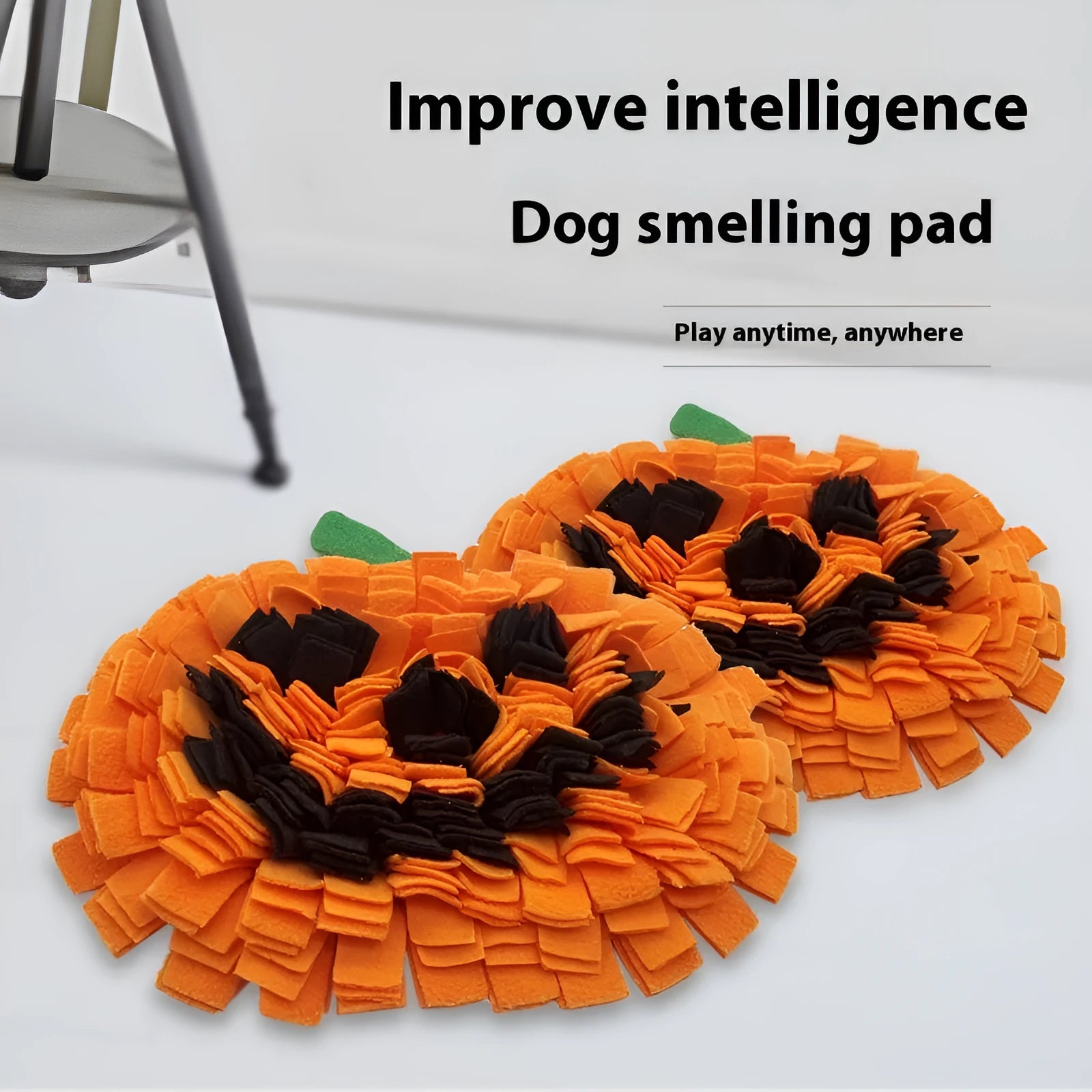 Orange pumpkin-shaped pet slow feeder mat on floor with scattered kibble