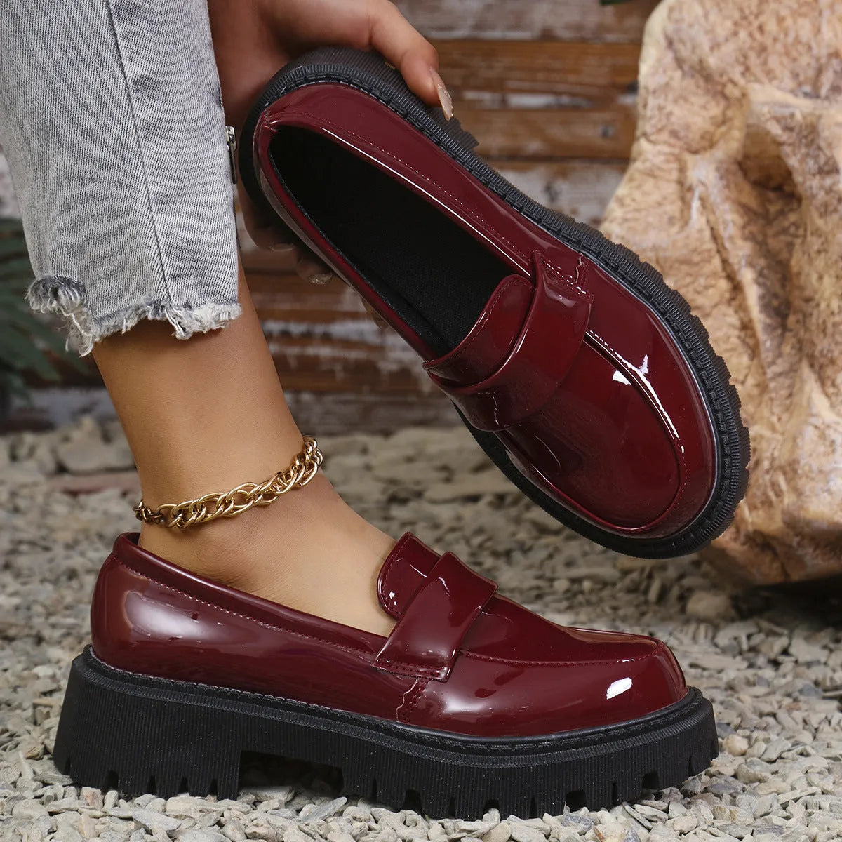 Women's black slip-on loafers with a chunky block heel and platform sole, shown from the side.