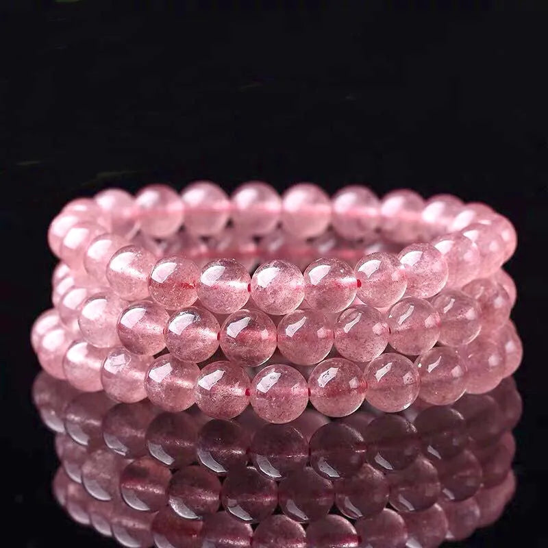 Women's strawberry quartz crystal bracelet showing polished beads in 6mm, 8mm, and 10mm size options