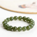 A close-up of a Hetian jade ball bracelet showing polished spherical beads in a clear stone colour, laid flat.