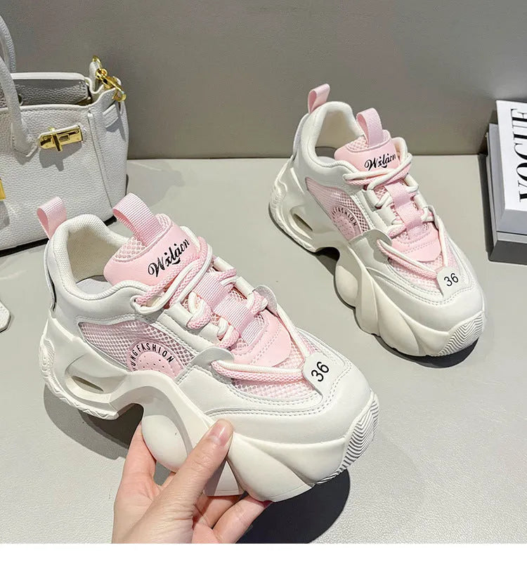 Women's pink sneakers with cross straps and a thick white platform sole.