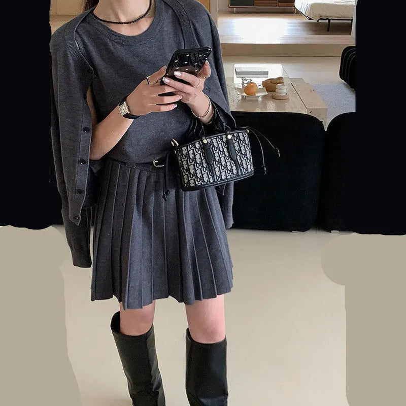 Women's black knitted polyester vest skirt and long sleeve cardigan two-piece set with a belt.