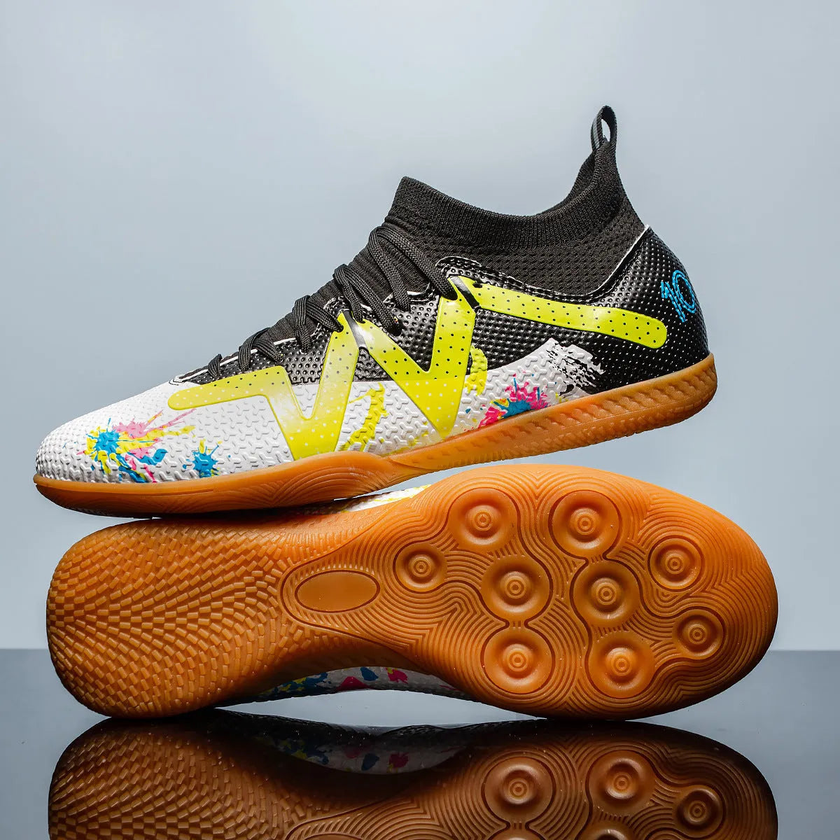 Men's black and yellow football boots with removable rubber studs on artificial grass
