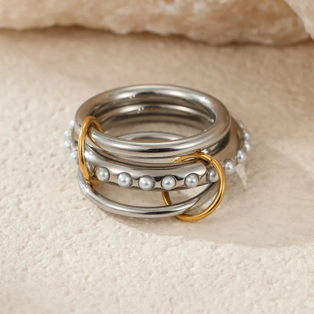 Stacked gold plated stainless steel ring set with exaggerated design on hand