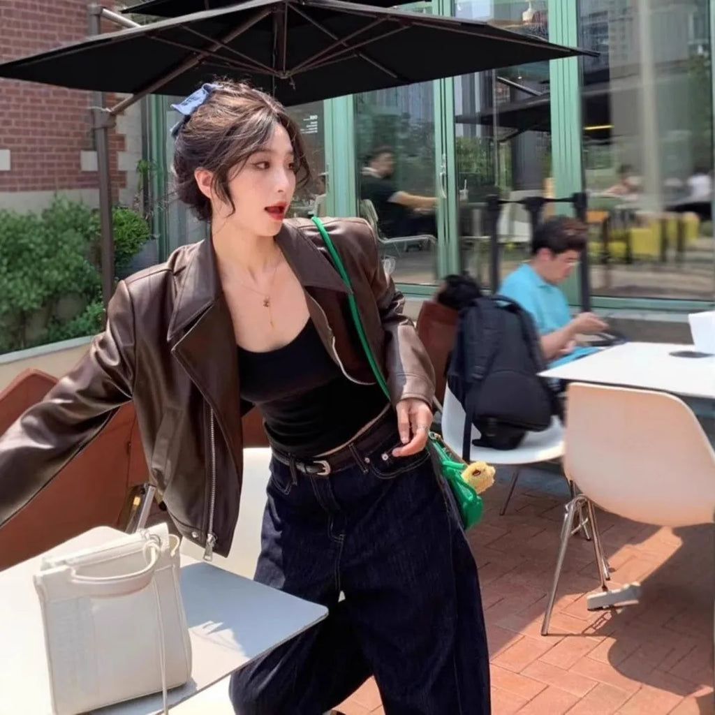 Women's slim-fit short brown retro leather jacket with long sleeves and a pocket.