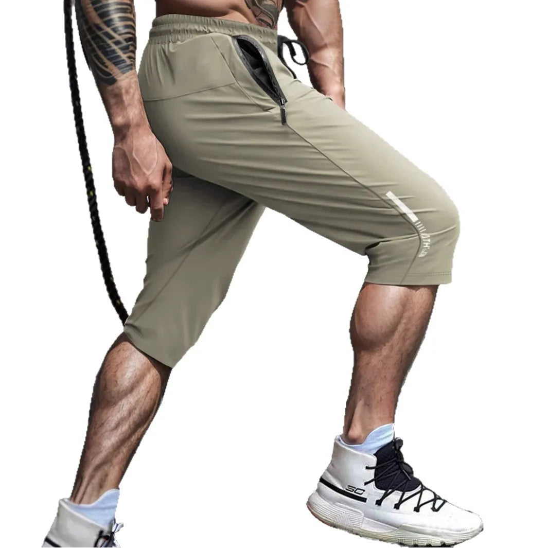 Man wearing grey cropped nylon sports pants with straight leg for summer beach activity