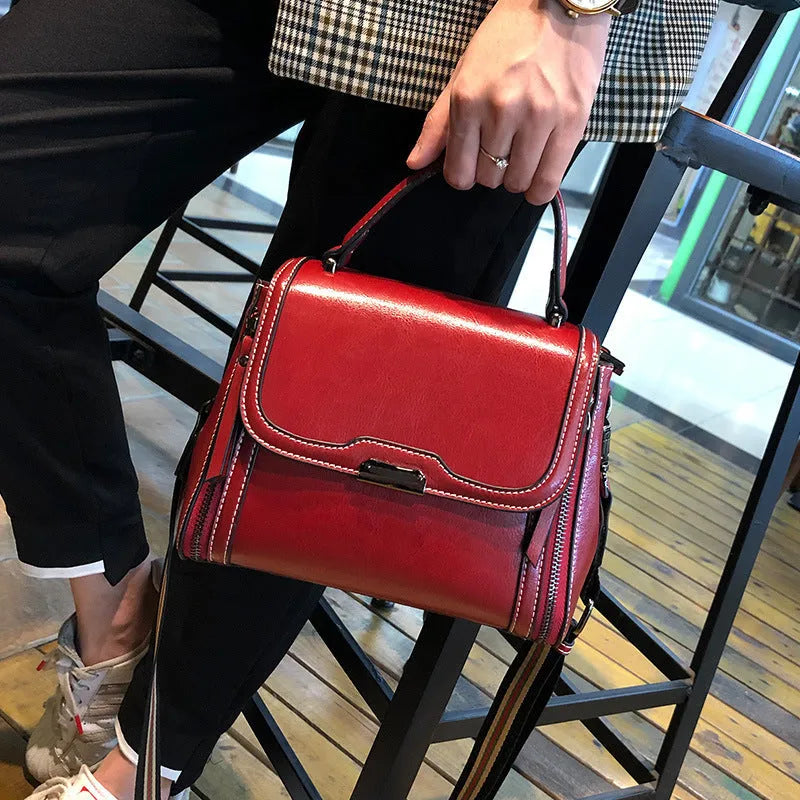 Women's brown genuine leather messenger bag with retro styling and multiple internal pockets