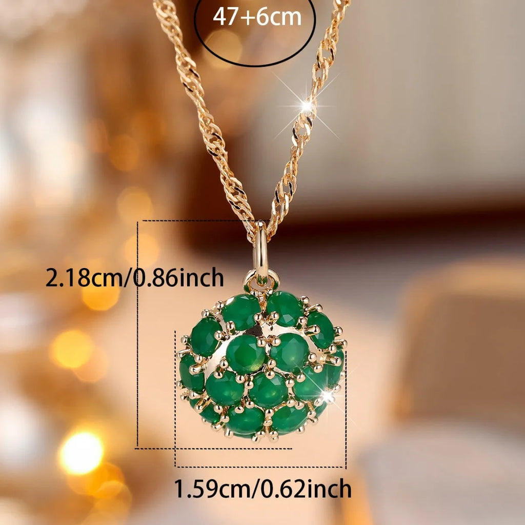 Champagne gold geometric pendant necklace with a round emerald stone and diamond accents on an adjustable chain.