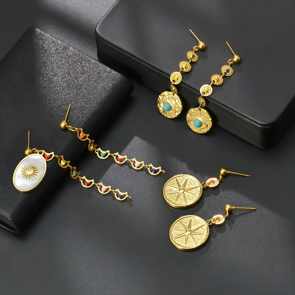 Three pairs of geometric stainless steel stud earrings showing star, eye, and sun designs