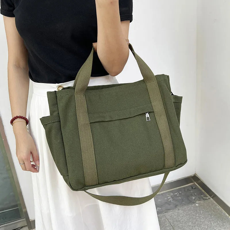Large khaki canvas tote bag for women with open top showing internal laptop and camera pockets