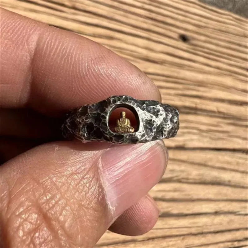 Hand-forged copper Grotto Buddha ring with a rock-textured surface, shown on a size 8 finger.