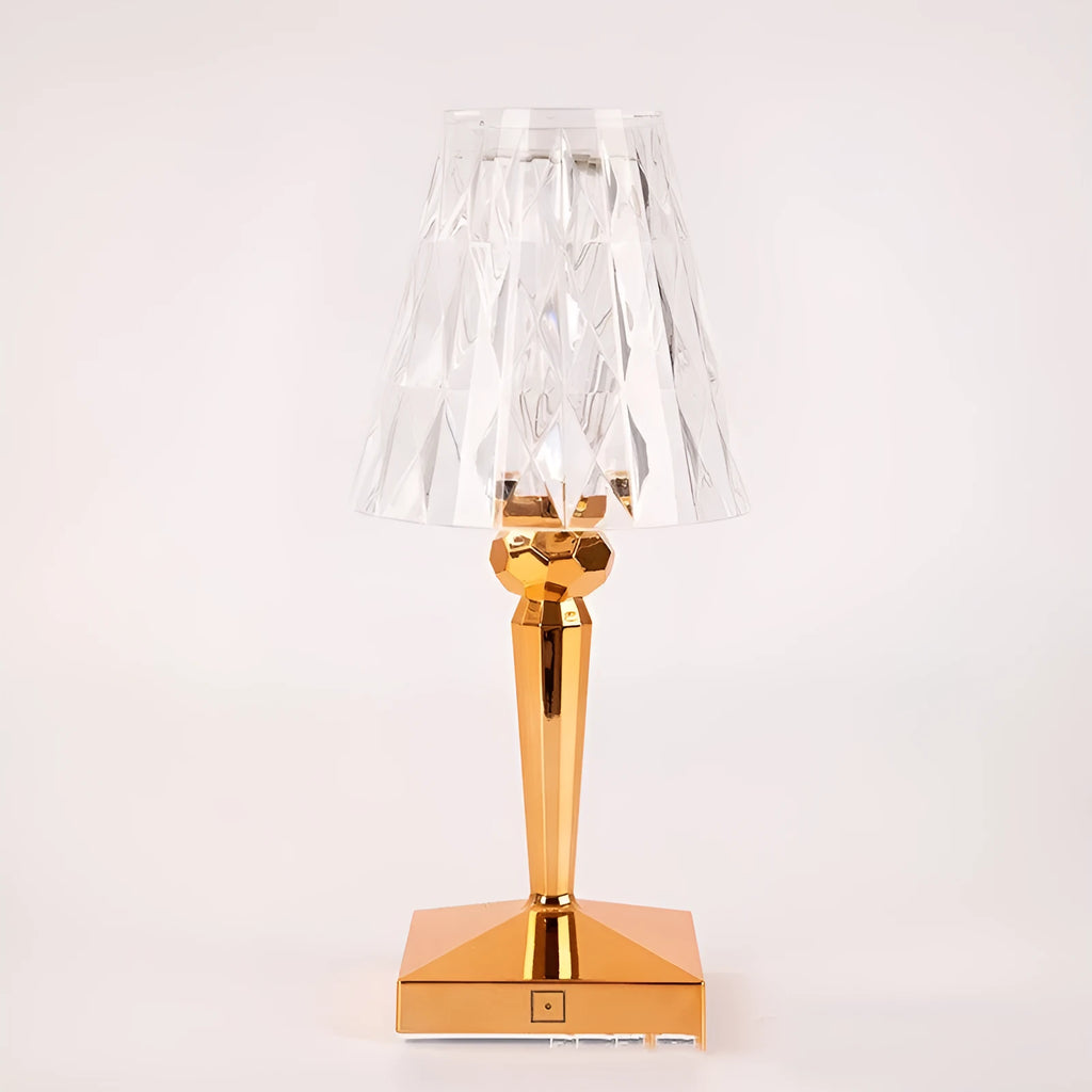 Rose gold portable touch projection night light on a wooden surface.