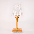 Rose gold portable touch projection night light on a wooden surface.