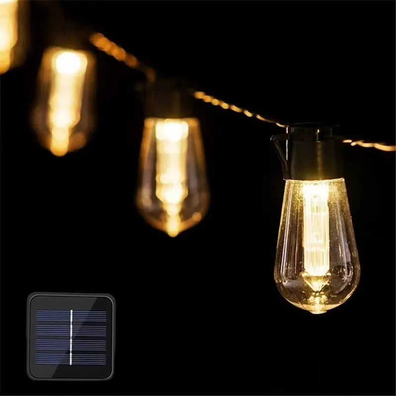 Retro glass infusion bottle-shaped outdoor string lights draped in a garden setting.