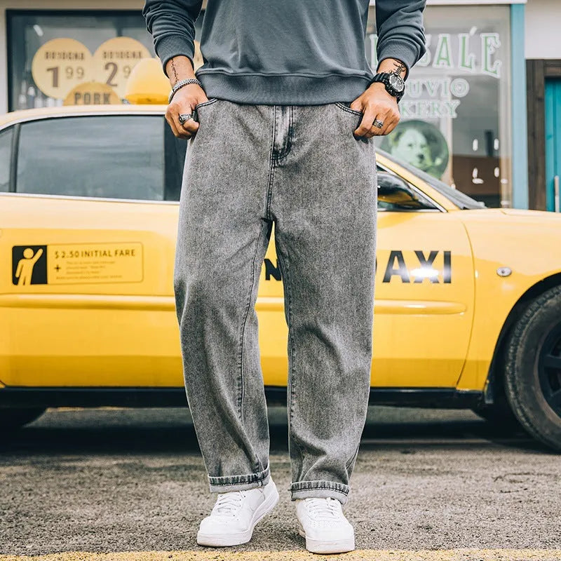 Man wearing loose straight-leg casual jeans in dark blue cotton fabric.