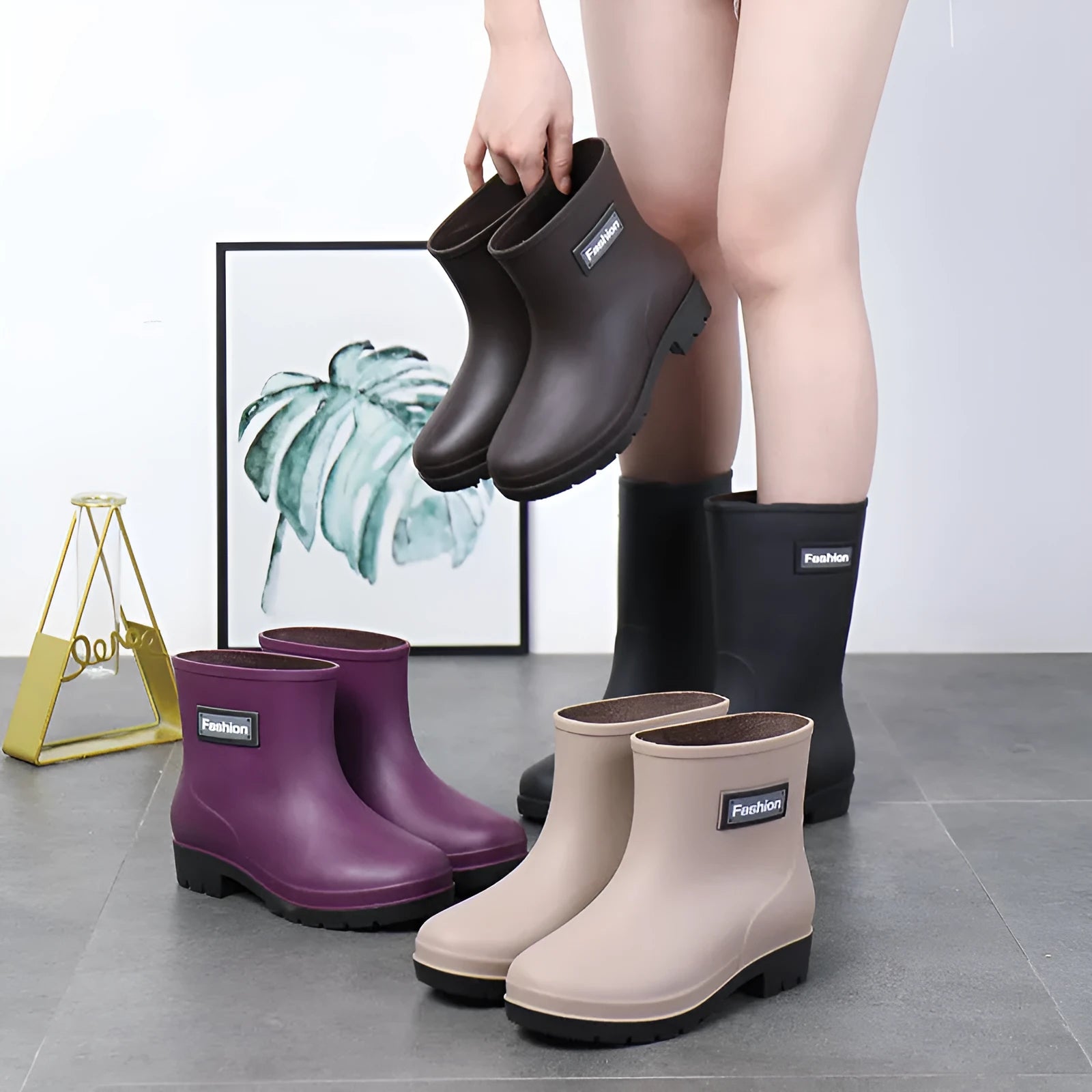Women's mid-calf PVC rain boot in black with a low heel on a white background.