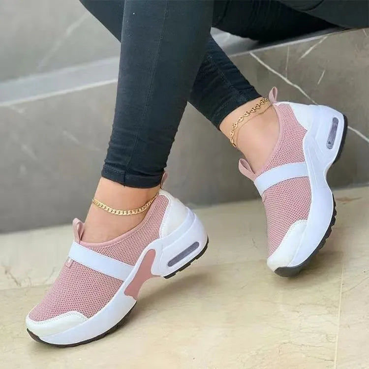Women's flat sneakers in light grey with mesh upper, round toe, and rubber sole.