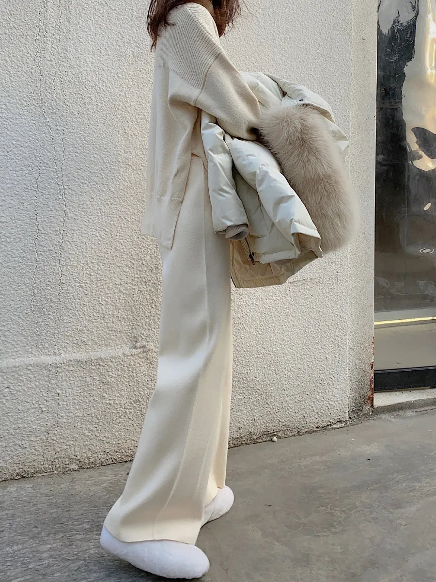 Women's cream white thick knitted wide-leg trousers with a high waist and drooping hem laid flat.