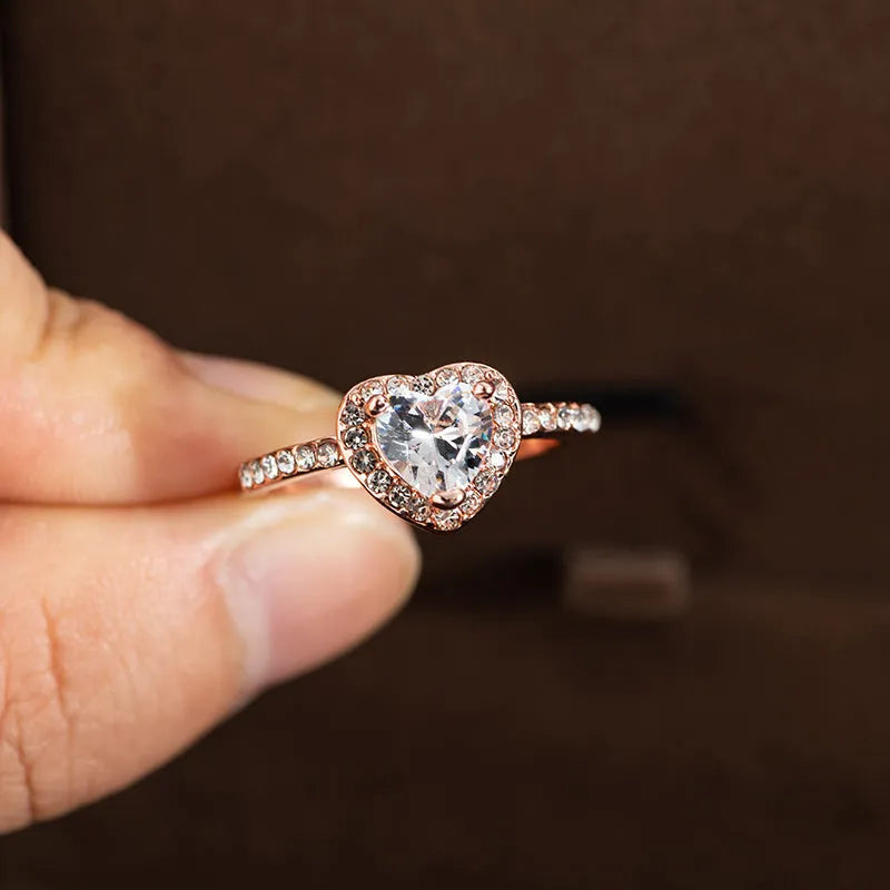 Heart-shaped women's ring with crystal decoration in rose gold or silvery finish on a size chart.