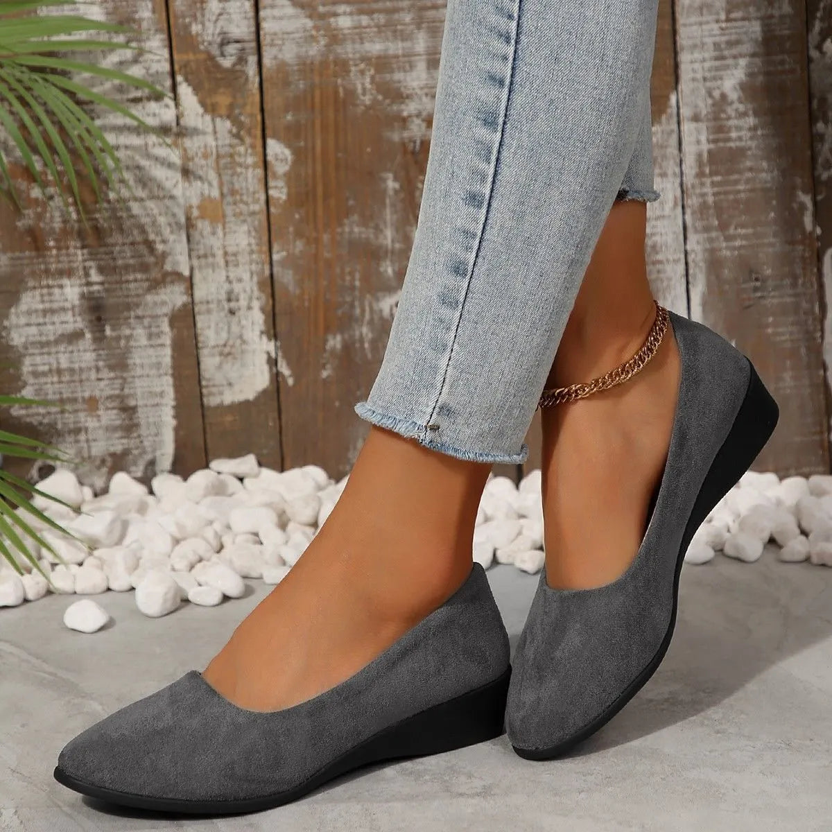 Women's suede wedge pump in light brown with a pointed toe and low rubber sole.