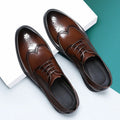 Men's classic black and brown brogue leather shoes with wingtip design on a white background.