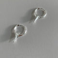 A pair of platinum-coloured geometric star-shaped ear clips for women on a white background.