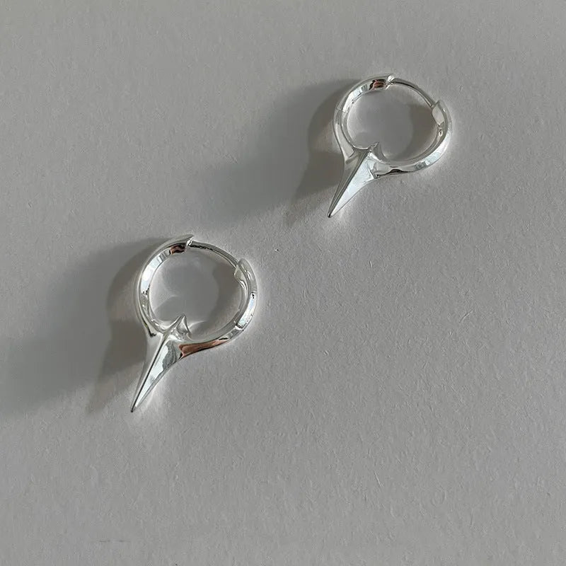 A pair of platinum-coloured geometric star-shaped ear clips for women on a white background.