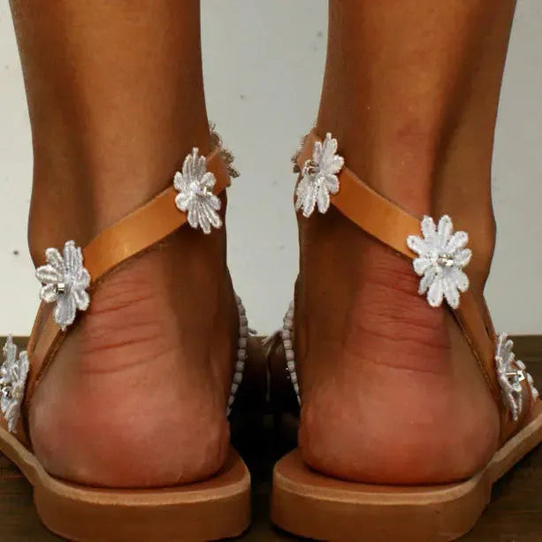 Brown flat-bottom Roman sandals with flower pattern and herringbone toe design