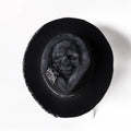 Handmade wool felt denim skull hat with a black conical crown on a white background.