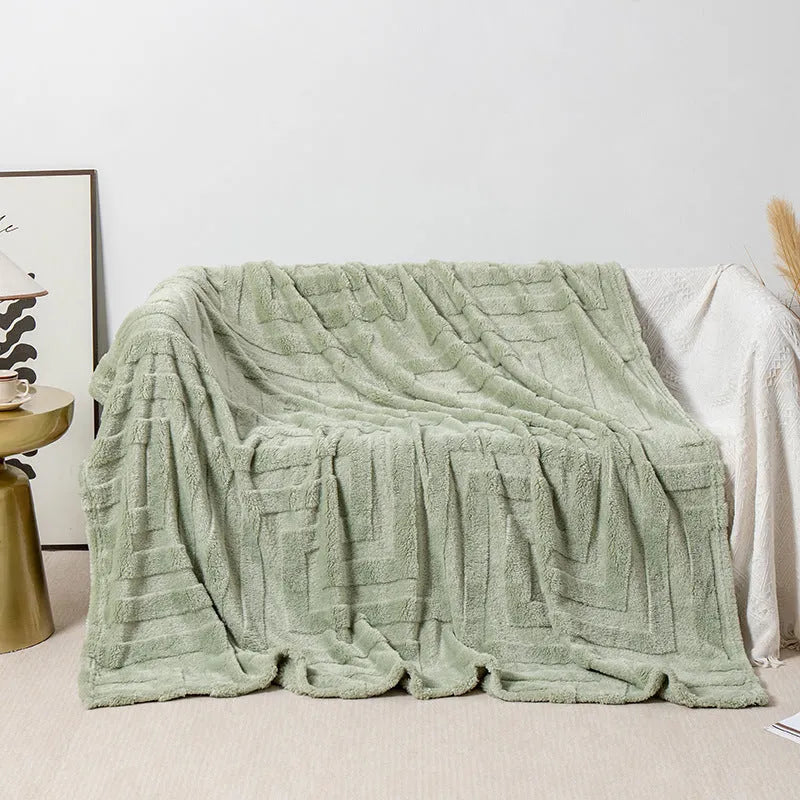 Thick coral fleece sofa blanket in a choice of colours and sizes draped over a grey sofa