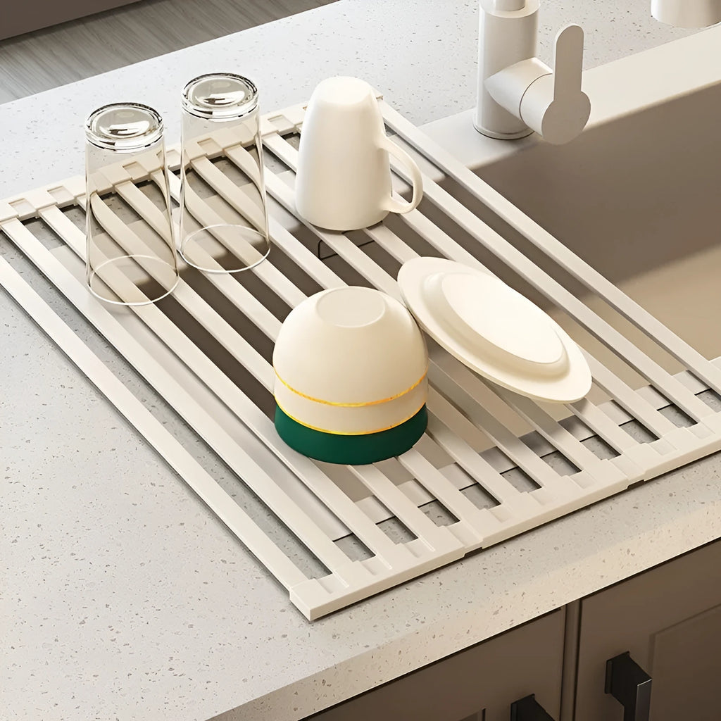 Milky white foldable stainless steel kitchen draining rack next to a sink.