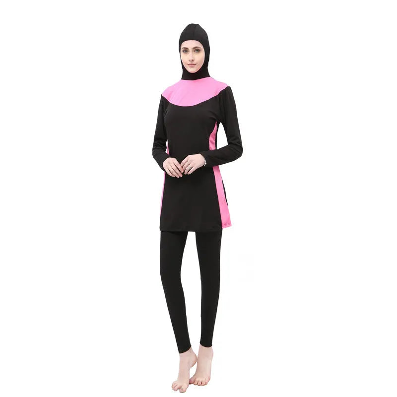 Women's black long sleeve hooded swimsuit with separate pants, shown on a model.