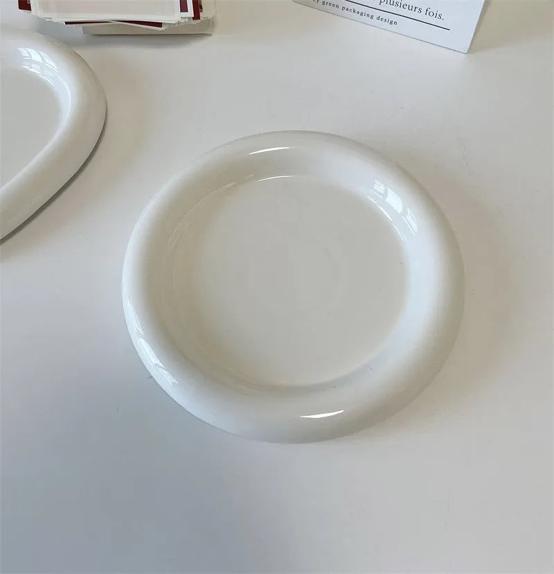 White round ceramic plate with bear doodle design, used as a saucer for a small succulent plant pot.