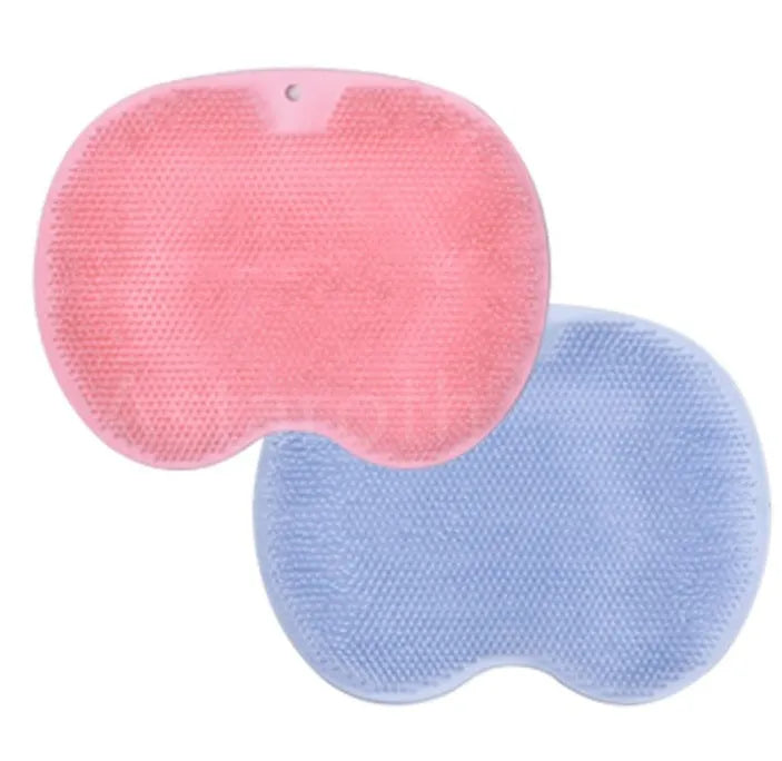 Orange suction cup bath brush with silicone bristles for foot and back cleaning on a bathroom floor.
