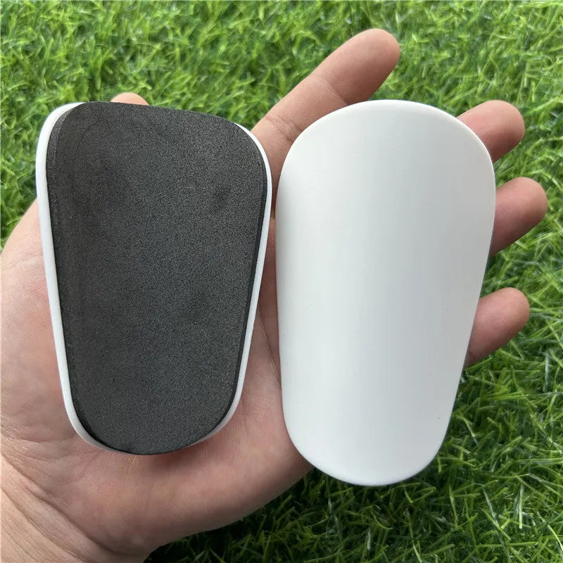Extra small mini football shin guards in black and white plastic construction