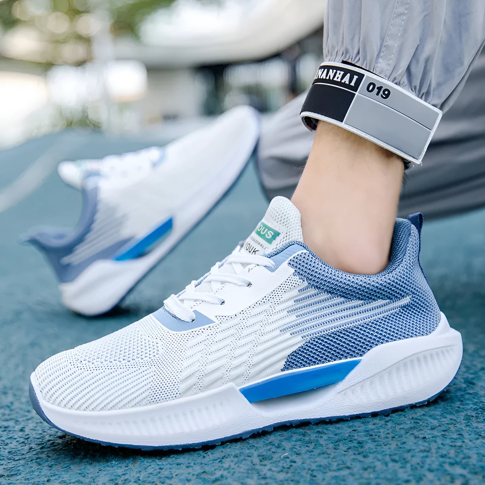 Men's blue mesh sports shoes with round toe and plastic sole on a grey background.