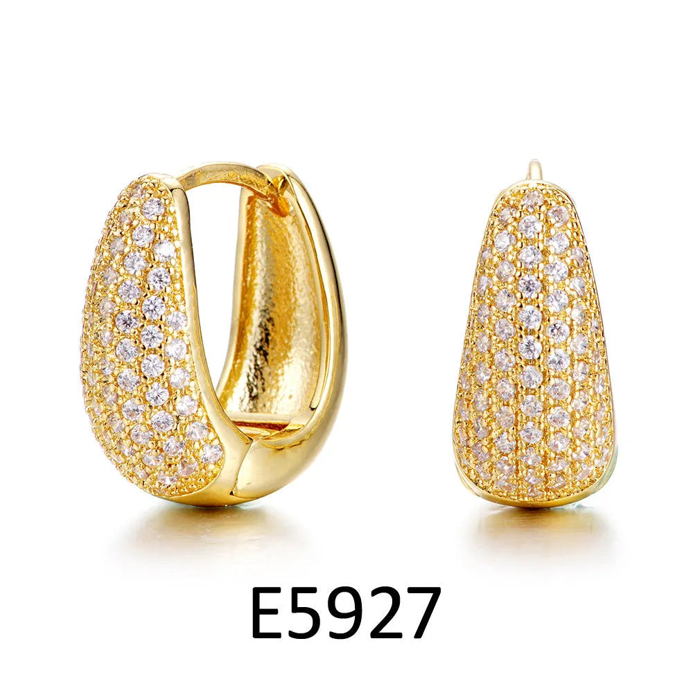 Gold plated brass heart-shaped ear clip earrings with zircon detail on a white background.
